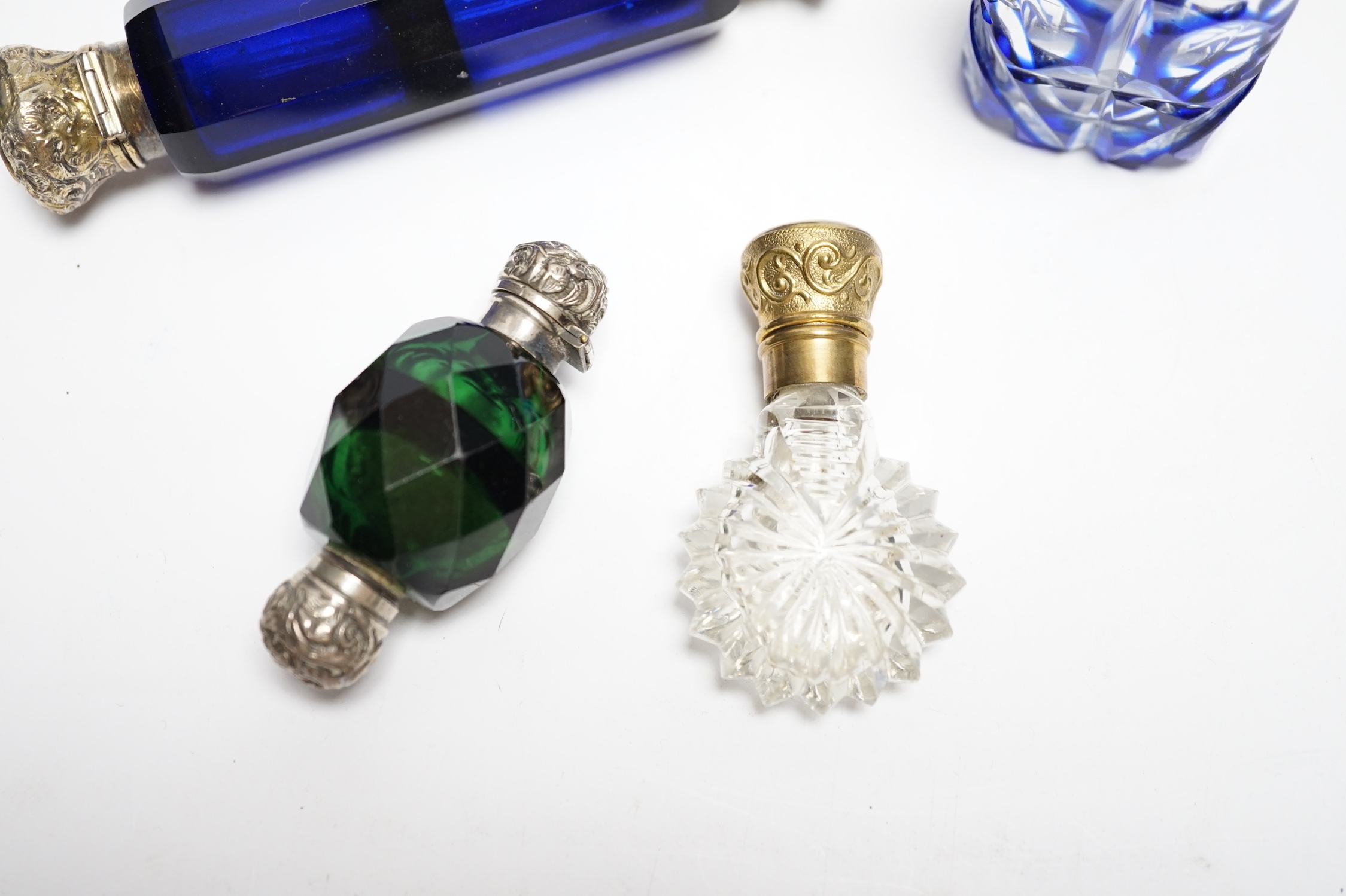 Four assorted Victorian white or gilt metal mounted cut glass scent bottles, including double ended blue glass scent bottle, 12.2cm.